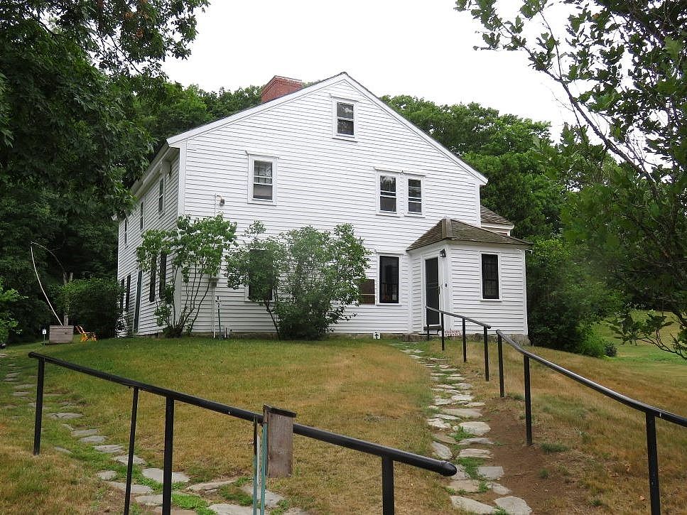 Home of poet John Greenbleaf Whittier. White farmhouse with stone paths leading the its entrance